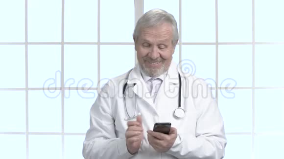 快乐的老医生用他的智能手机视频的预览图