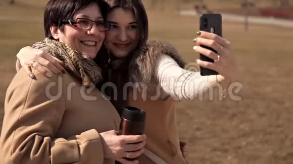 夏天妈妈和成年女儿在公园里自拍疯狂地笑着快乐而积极的情绪父母视频的预览图