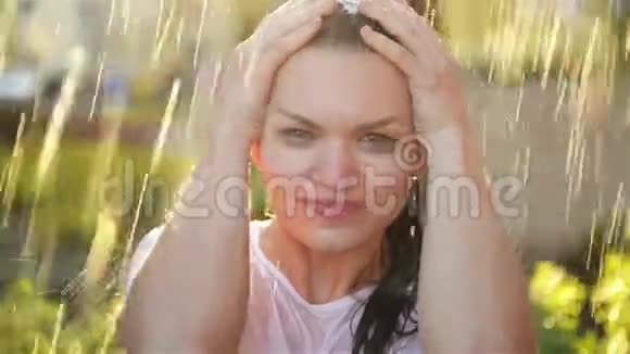 年轻的女人在雨中笑雨滴落在她的脸上她对生活和自然感到快乐视频的预览图