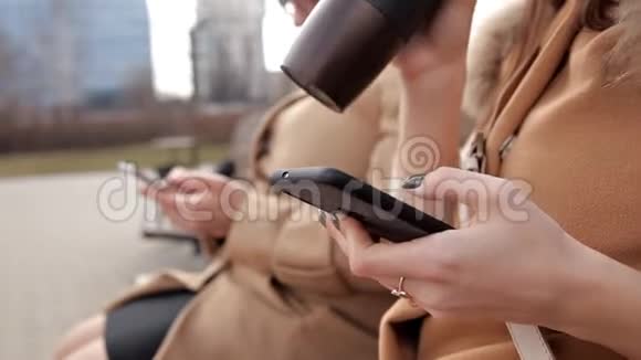 母女俩坐在公园里用手机写短信视频的预览图