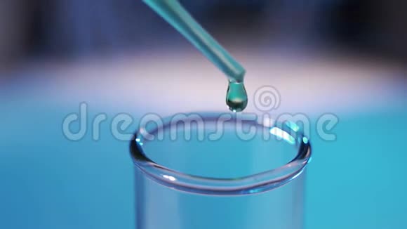 吸管在彩色背景上将透明蓝色化学物质滴入试管中视频的预览图