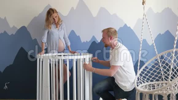 年轻的家庭在山上为未出生的孩子收集婴儿床孕妇及其丈夫视频的预览图