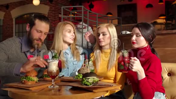 一群年轻快乐的朋友在时髦的咖啡馆里吃美味的汉堡视频的预览图