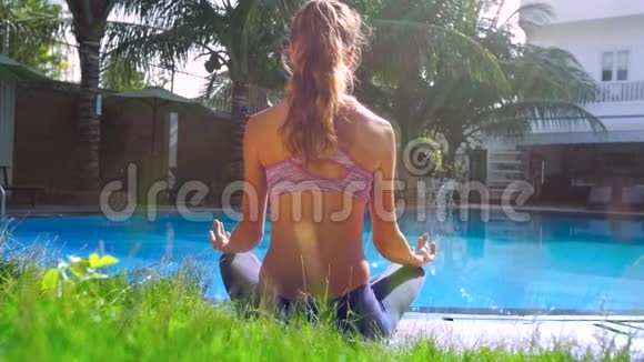 女士放松坐在游泳池边的瑜伽姿势视频的预览图