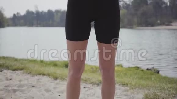 迷人的苗条女孩做运动锻炼站在河岸上背景中的优美景观休闲视频的预览图