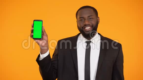 穿着正式服装微笑的美国黑人男子展示预先准备好的电话广告视频的预览图