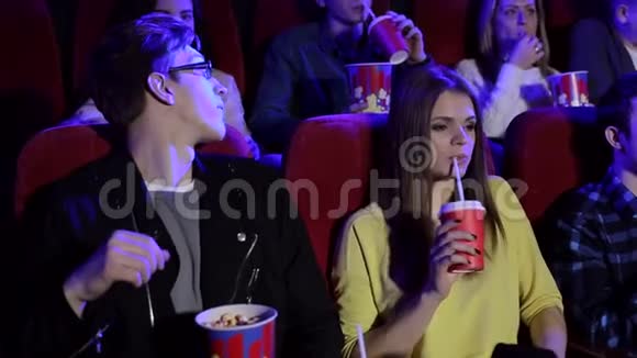 在电影院里坐在红色椅子上看电影的青少年特写视频的预览图