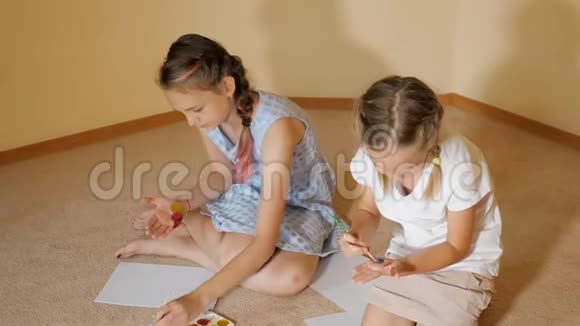 女孩在纸上和手上画水彩视频的预览图