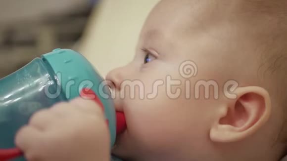 可爱的小男孩在家里用瓶子吸水视频的预览图