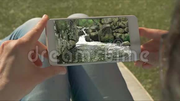 人类手拿着带有水梯级视频的手机视频的预览图