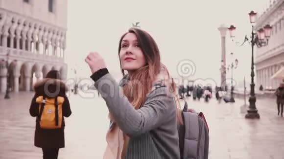 美丽的年轻女子游客转过身来兴奋微笑在旧的圣马克城广场在威尼斯意大利慢动作视频的预览图