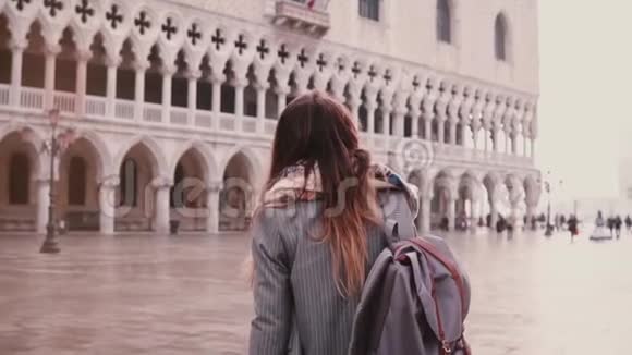美丽的年轻女子游客走在令人惊叹的旧圣马可城广场在威尼斯意大利回首慢动作视频的预览图