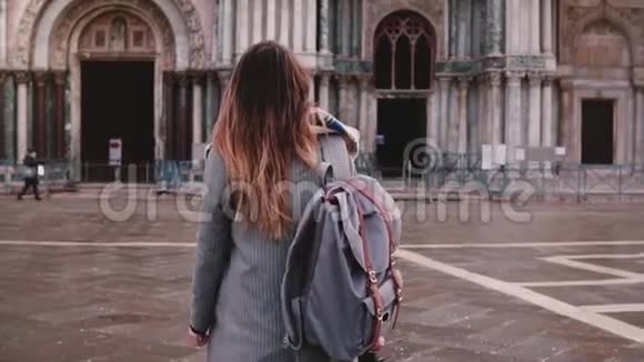 美丽的女游客背着背包步行到令人惊叹的意大利威尼斯古玩建筑回首慢动作视频的预览图