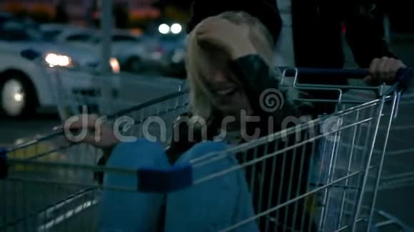 慢动作两位年轻的千禧一代女孩正在超市里玩着购物车和火花车视频的预览图
