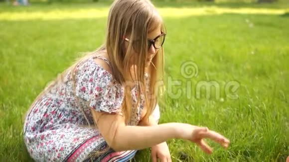 两个十几岁的女朋友在公园里坐在草地上下棋学校假期青少年智力游戏视频的预览图
