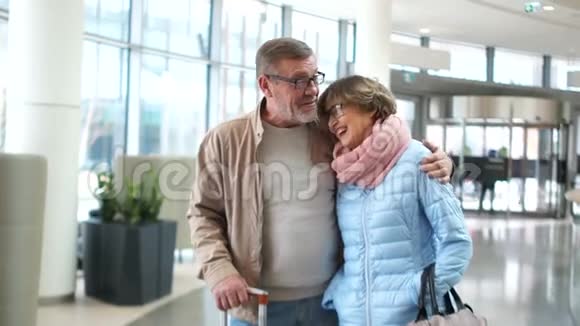 一对退休夫妇在机场他们互相看着开心地笑着旅行目的地视频的预览图