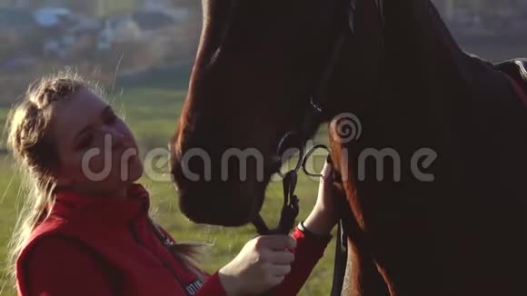 马女在日落时亲吻一匹马慢动作侧视关门视频的预览图