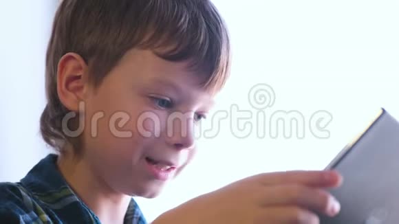 快乐男孩正在玩平板电脑游戏脸特写视频的预览图