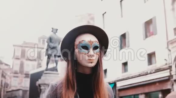 意大利威尼斯街长发戴着白色狂欢节面具的女人看着相机回头视频的预览图