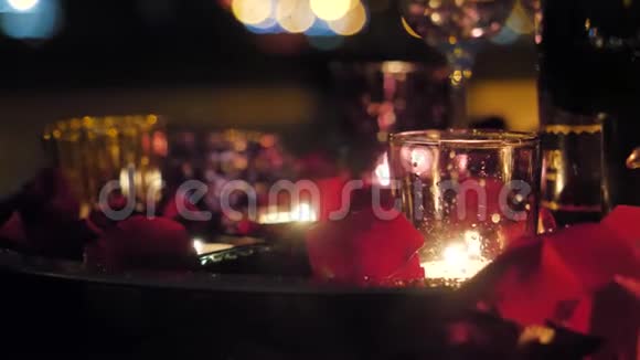 浪漫的夜晚用玫瑰花瓣点燃蜡烛视频的预览图