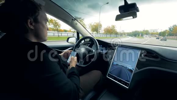 男司机工作带手机坐在汽车上自动驾驶关门视频的预览图