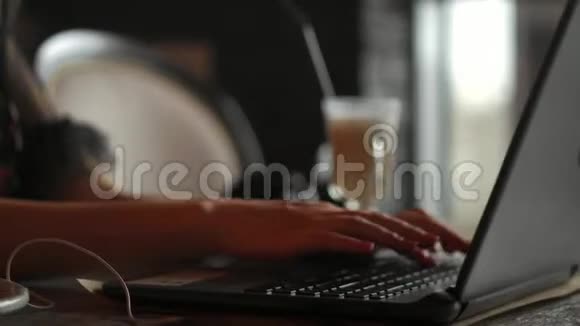 戴眼镜的年轻漂亮女人正在咖啡馆里工作听着音乐微笑着视频的预览图