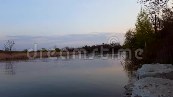早晨的河流场景与背景的卡诺在白天夏天人们穿着独木舟在河畔流淌视频的预览图