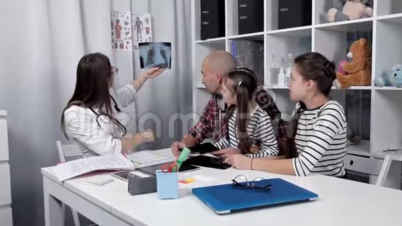 一个年轻人把他的孩子带到医生办公室检查咨询治疗视频的预览图