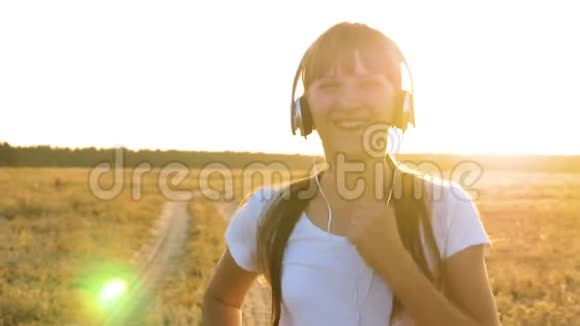 戴着耳机的漂亮女孩听音乐参加运动慢跑和微笑体育作为生活方式视频的预览图
