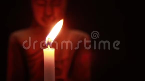在黑暗中吹灭蜡烛在黑色背景上吹灭佛像视频的预览图