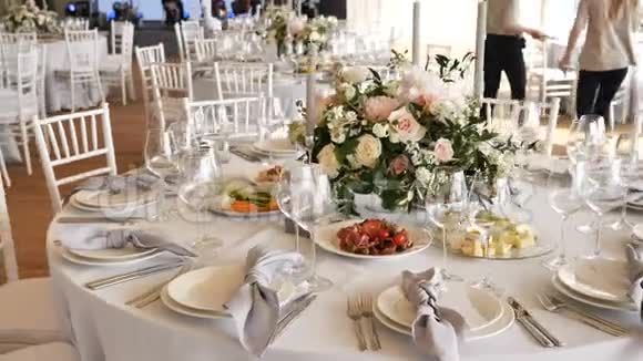宴会上有大桌子白色桌布各种美味的菜肴鲜花和玫瑰蜡烛视频的预览图