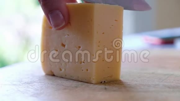 一位中年厨师在木板上用刀切奶酪特别靠近视频的预览图