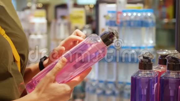 女性手拿着洗发水或沐浴露化妆品商店的女性阅读产品成分消费主义概念视频的预览图
