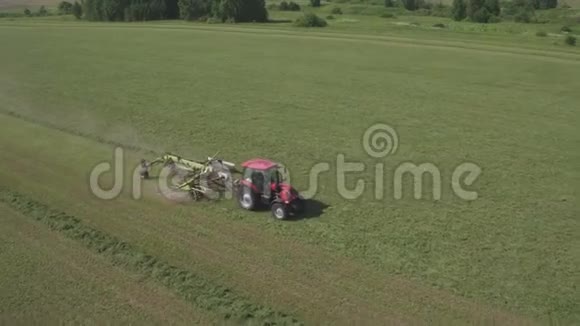 在大田里工作的农用拖拉机的空中视野在田里工作的收割机在田里工作的红色拖拉机视频的预览图