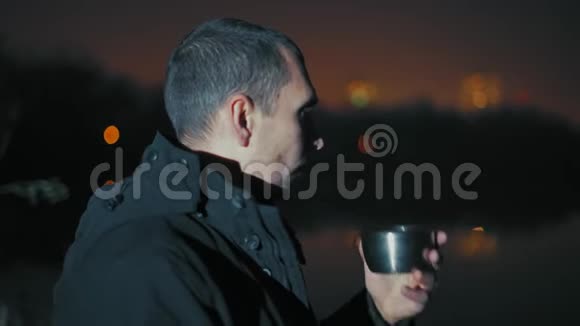 特写镜头男士远望河岸晚饮茶视频的预览图
