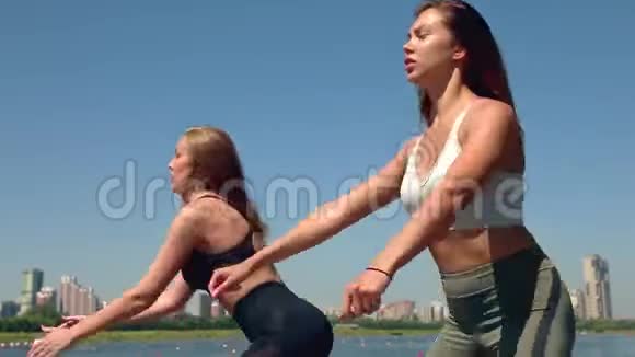 两个女人在城市的河岸上做运动户外运动视频的预览图