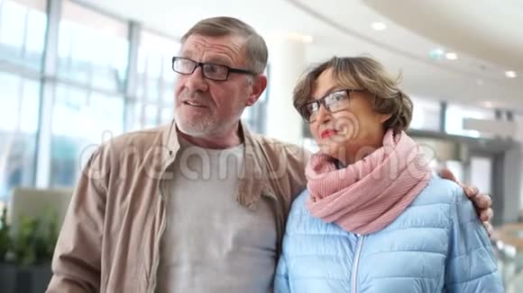 在机场的老夫妇男人和女人在休息室里交谈望着远处等待你的航班视频的预览图