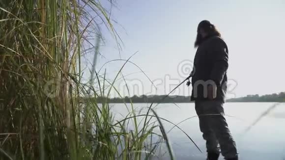 长胡子的人在河岸上钓鱼渔夫正试图钓鱼但它逃脱了河流捕鱼视频的预览图