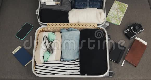 女人手里拿着手提箱在家里的床上旅行旅行准备视频的预览图