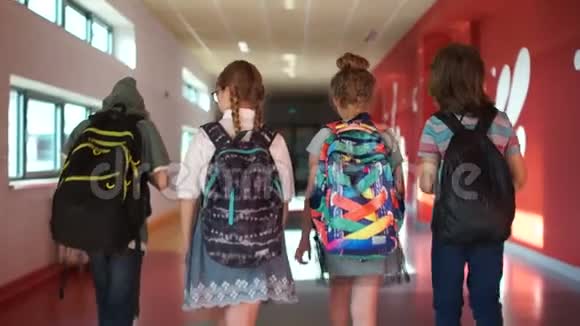 学生穿过学校走廊两个男孩和两个女孩孩子们背背包回学校去背面视频的预览图