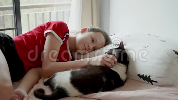 可爱的少女在床上玩她的猫视频的预览图