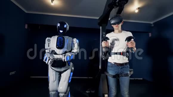 像人一样的机器人和一个戴着虚拟现实护目镜的十几岁的男孩正一起向前投掷视频的预览图