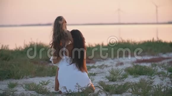 妈妈和女儿坐在沙滩上眺望远方视频的预览图