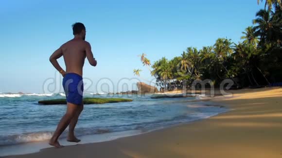 运动体操运动员在蓝天下沿着黄滩奔跑视频的预览图