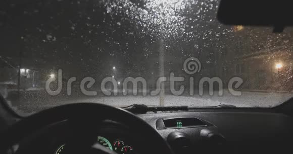 雪落在汽车上玻璃在晚上融化内景视频的预览图