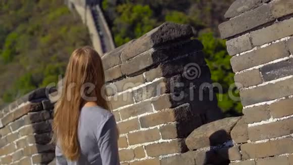 史泰迪康拍摄了一位年轻女子她看着中国长城的开幕式墙从墙的一侧升起视频的预览图