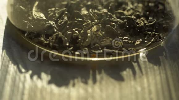 冲泡绿茶在透明水壶特写玻璃茶壶中的异国绿茶花宏观拍摄的过程视频的预览图