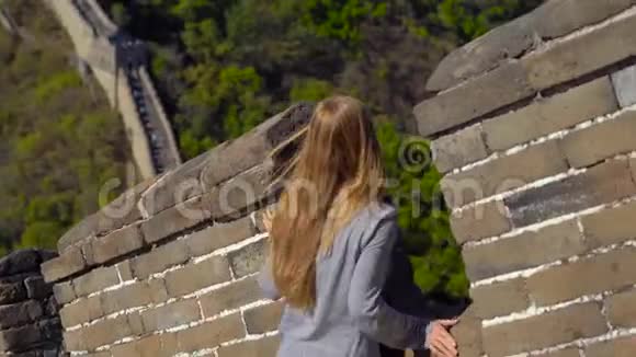 史泰迪康拍摄了一位年轻女子她看着中国长城的开幕式墙从墙的一侧升起视频的预览图