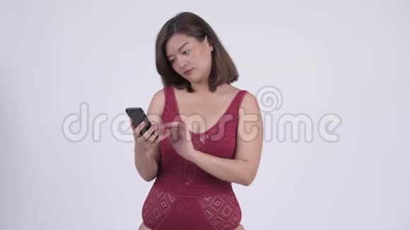 年轻快乐的亚洲旅游妇女使用电话得到好消息视频的预览图
