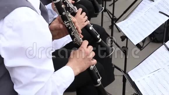 男音乐家在市政管弦乐队中演奏单簧管在节日的露天演出视频的预览图